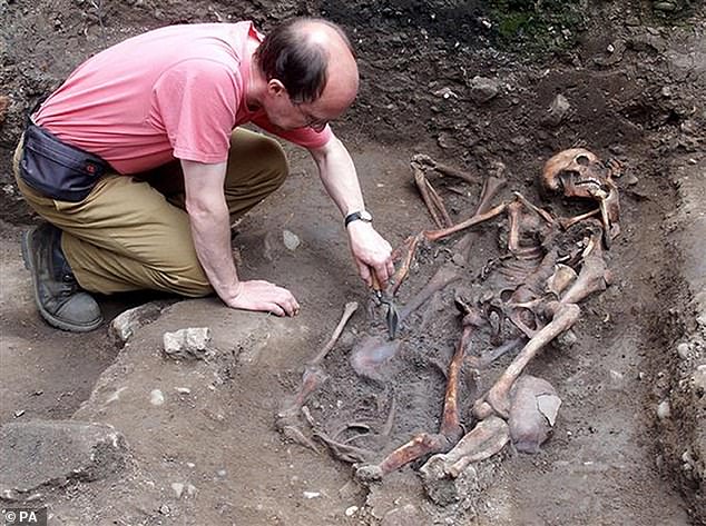 Kurt Hunter-Mann, a field officer at York Archaeological Trust, examines another skeleton unearthed at the site in York