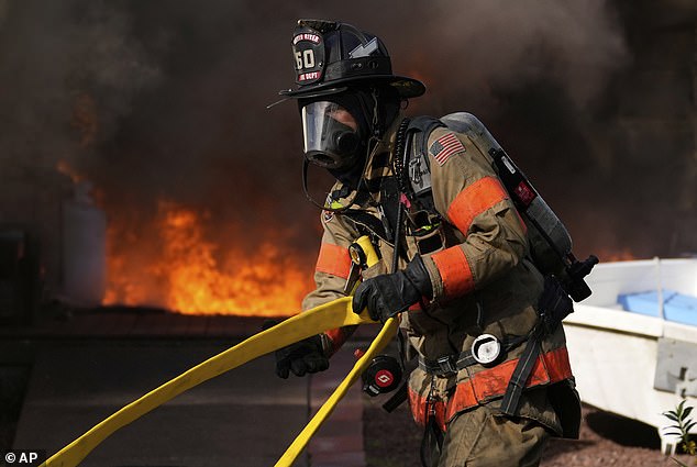 Firefighters battle a house fire Wednesday, April 23, 2025, in Lacey Township, New Jersey