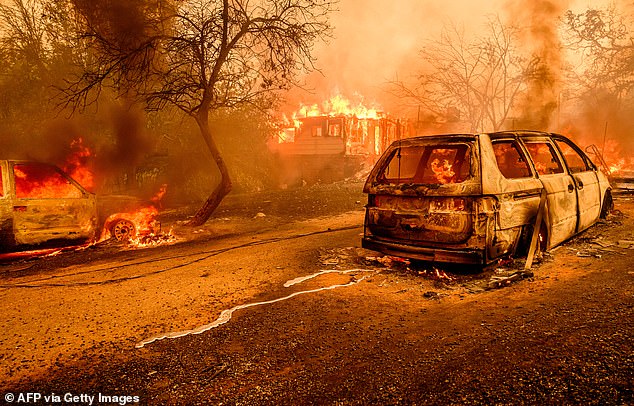 Molten metal from a burned car meanders on the road as flames engulf a home during the Thompson fire in Oroville, California on July 2, 2024