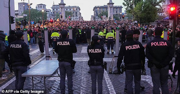TOPSHOT - Police officers stand guard as people queue on the street ahead of late Pope Francis' funeral near the Vatican, in Rome on April 26, 2025. Pope Francis, champion of the poor and the Church's first Latin American leader, will be honoured April 26 with a funeral attended by world leaders and tens of thousands of Catholic faithful. The Argentine pontiff, who died on April 21, 2025, aged 88, sought to create a more open-minded Church during his 12-year papacy, and many emotional tributes have been made -- with 250,000 people paying respects at his coffin in St Peter's Basilica. (Photo by Dimitar DILKOFF / AFP) (Photo by DIMITAR DILKOFF/AFP via Getty Images)