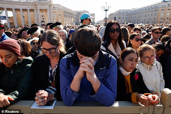 People pray while waiting for the start of the funeral mass of Pope Francis,  in St. Peter's Square at the Vatican, April 26, 2025. REUTERS/Susana Vera     TPX IMAGES OF THE DAY