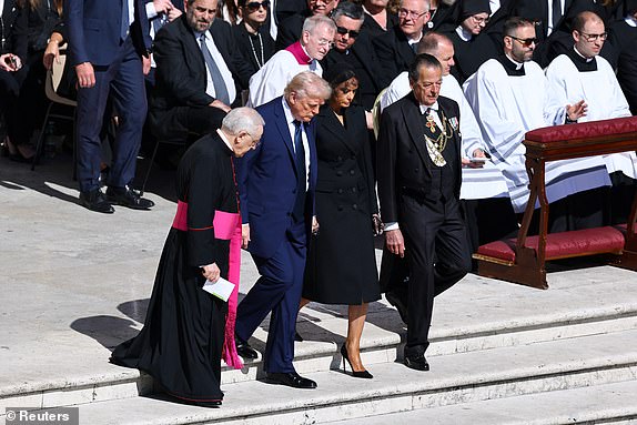 U.S. President Donald Trump and first lady Melania Trump walk, on the day of the funeral Mass of Pope Francis, at the Vatican, April 26, 2025. REUTERS/Kai Pfaffenbach