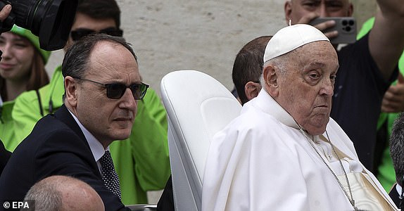 epa12046443 Pope Francis (R), accompanied by personal nurse Massimiliano Strappetti (L), greets the faithful after the Urbi et Orbi blessing following the Easter Mass in Saint Peter's Square, in Vatican City, 20 April 2025 (issued 22 April 2025).  EPA/ANGELO CARCONI