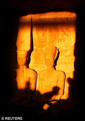 The sun's rays illuminate statues (pictured) inside the Great Temple at Abu Simbel in Egypt twice a year