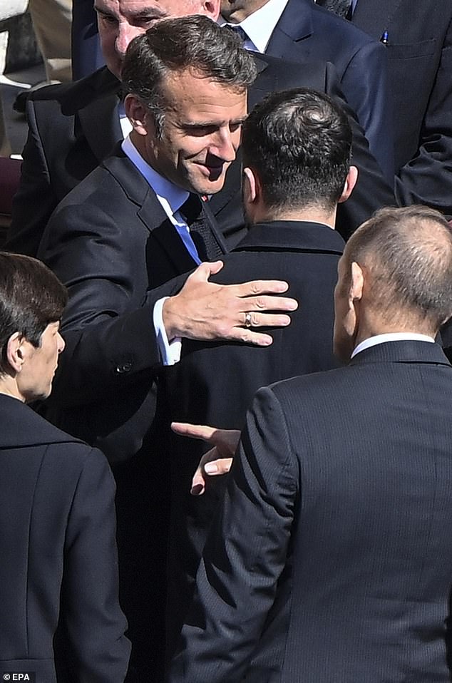 French President Emmanuel Macron (L) talks with Ukrainian President Volodymyr Zelensky during the funeral Mass
