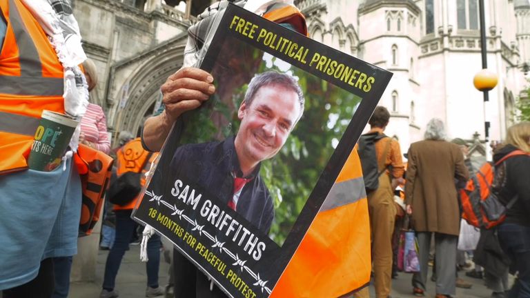 A JSO activist holds a picture of an imprisoned colleague