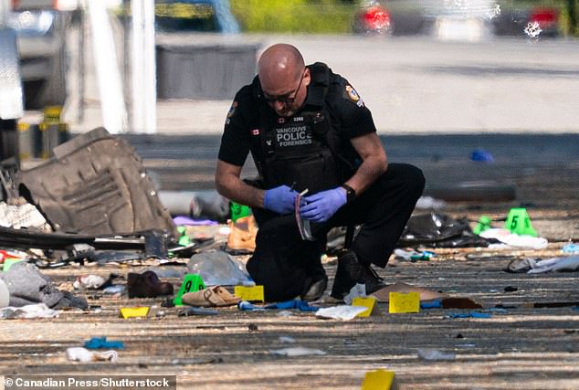 A member of the Vancouver Police forensics team collects evidence while investigating the scene where a vehicle drove into a crowd