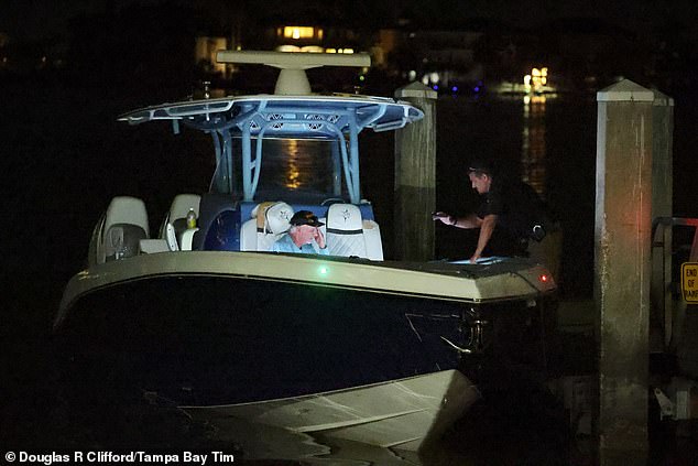 A man suspected of 'driving the boat' which crashed into the ferry is pictured here as he speaks with an investigator
