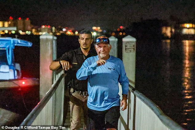 Pictured: A man exits the Belleair Boat Ramp alongside an investigator who is assessing the tragedy