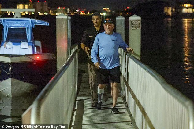 A man suspected of being behind the wheel of the boat that fled the scene is pictured walking with an investigator