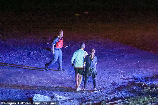 Pictured: A first responder rushing into the water to rescue passengers