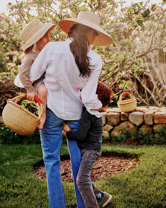 Meghan, 43, sat down for a raw, unfiltered chat with podcast host and the founder of IT Cosmetics, Jamie Kern Lima, that was published earlier today. She is pictured here with her Archie, five, and Lili, three, in a promotional photograph for her lifestyle brand As Ever