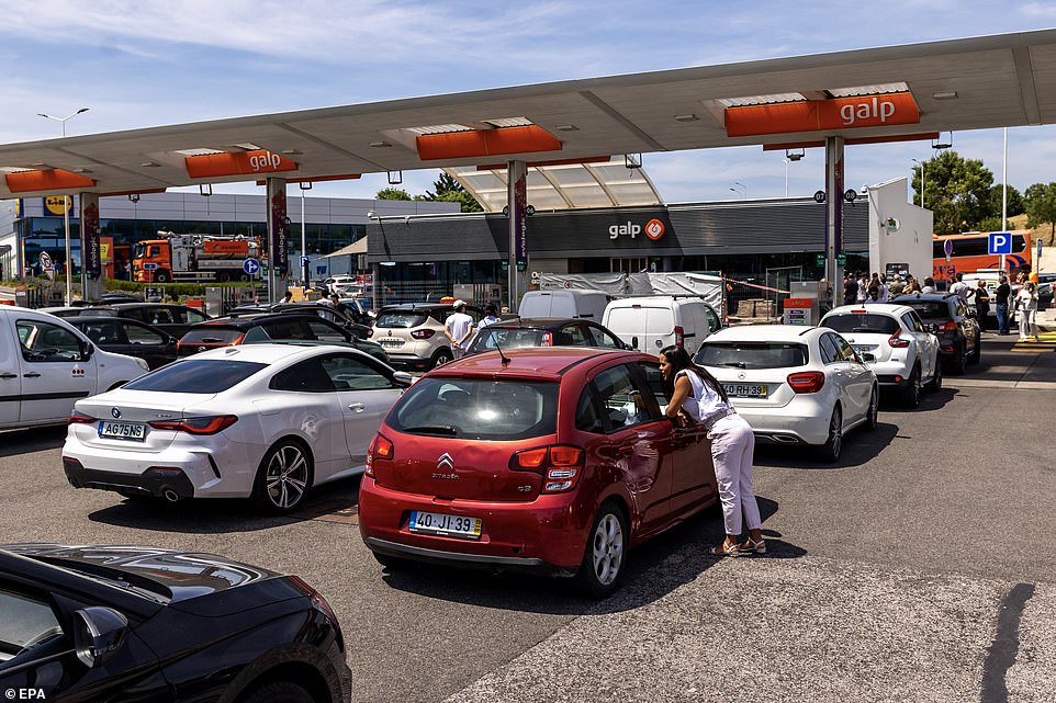 Drivers wait in line to fill up their vehicles with fuel at a service station in Portugal