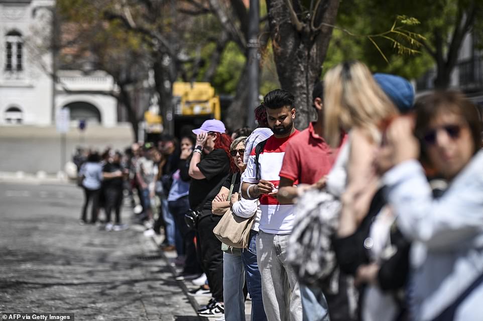 People queue at a bus stop at Rossio square, after the Lisbon subway has been stopped, in Lisbon on April 28