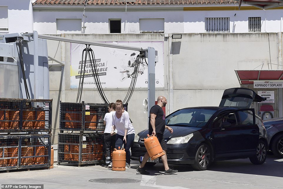 Customers buy gas bottles in a petrol station during a massive power cut affecting the entire Iberian peninsula and the south of France, in Seville
