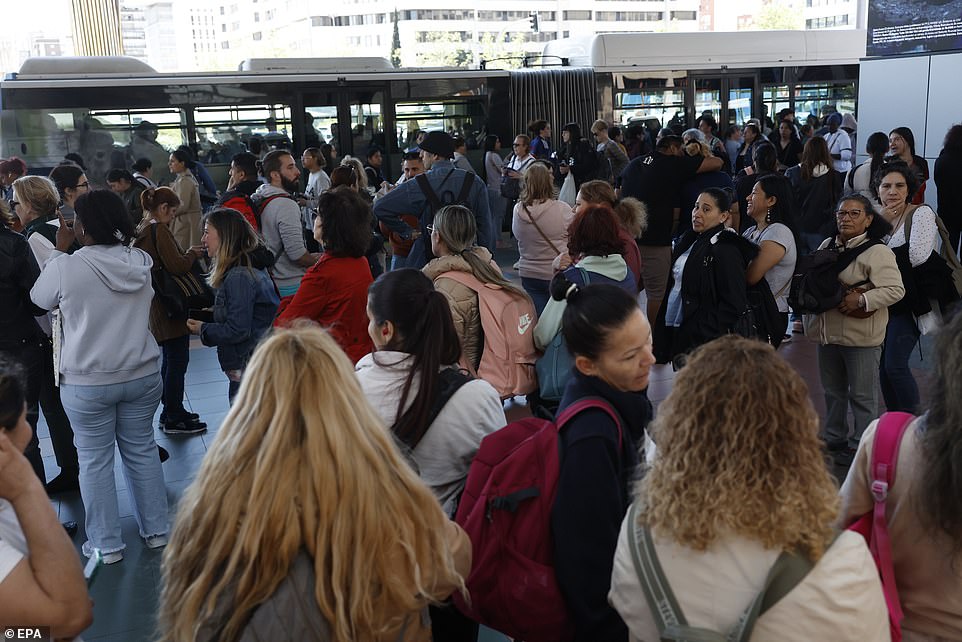 Commuters queue at a bus station after subway closed as a blackout hits Spain and Portugal in Madrid