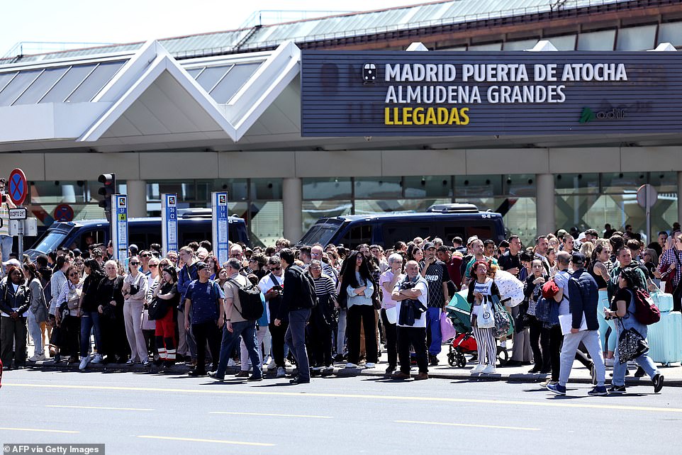 People leave the Atocha train station in Madrid after its closure as a massive power outage hit
