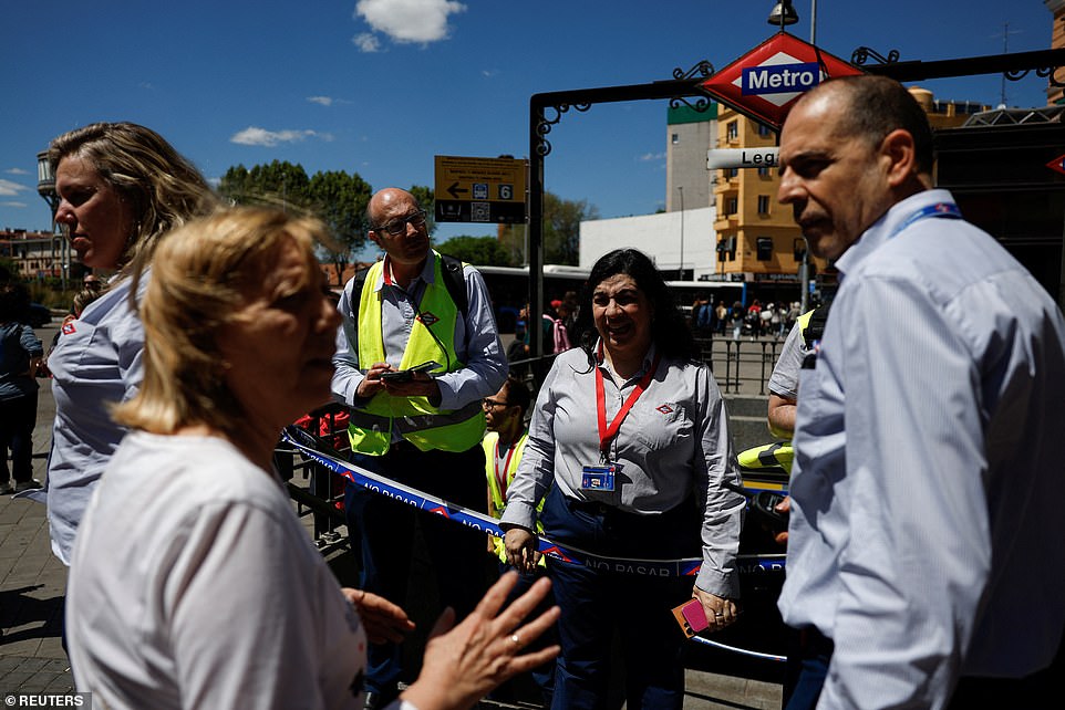 Metro workers explain to a woman that the metro is closed due to a power outage, in Madrid