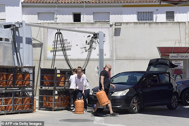 Customers buy gas bottles in a petrol station during a massive power cut affecting the entire Iberian peninsula and the south of France, in Seville