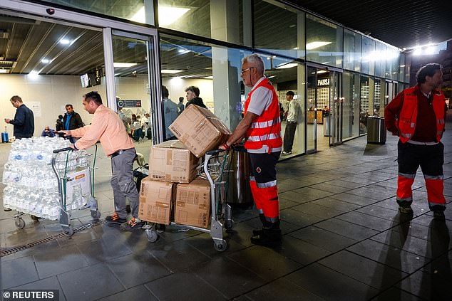 Members of the Red Cross pushes trolleys with water bottles and blankets near Joaquim Sorolla station, as a power outage hits large parts of Spain, in Valencia, Spain, April 28, 2025