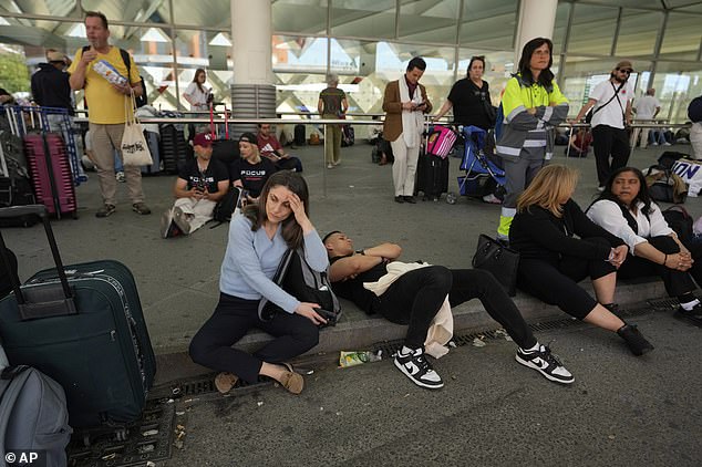 Passengers wait outside Atocha train station during a nationwide power outage