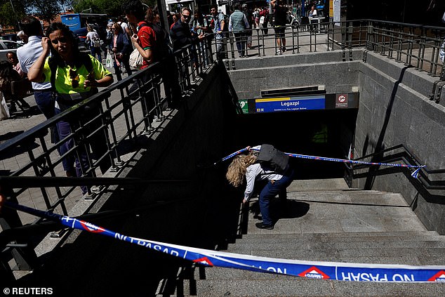 A metro worker passes underneath barricade tape, to enter Legazpi Metro station, after the metro was closed during a power outage