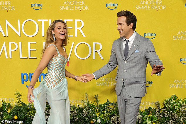 'It's hard to see if Blake's circling, winding hand gesture is aimed at someone else further along the red carpet or if it's a signal to Ryan to motivate him to set off to work the camera poses. It looks like she's winding up clockwork or doing some kind of countdown'