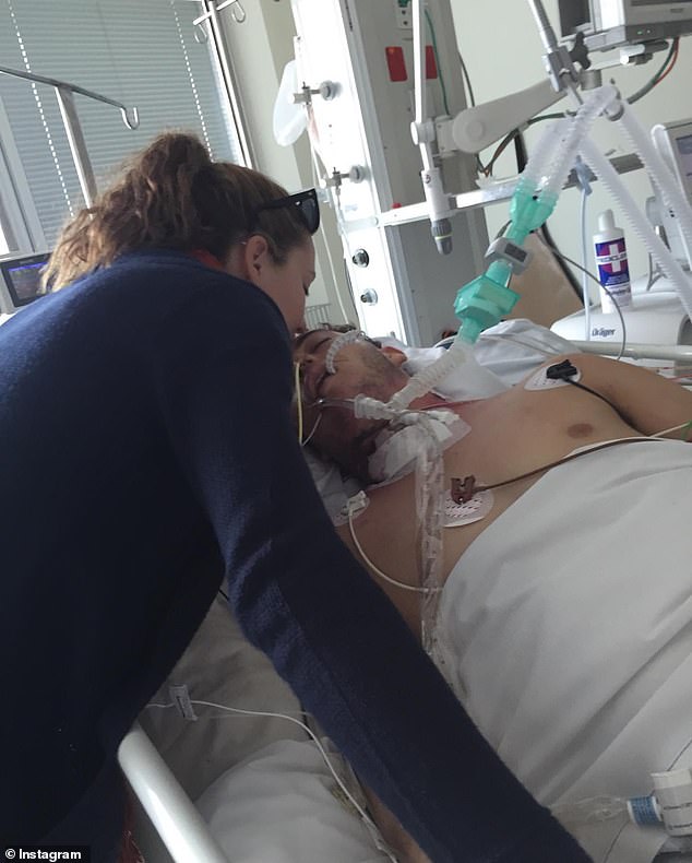Hurt is pictured in hospital with Evans just after he broke two vertebrae in his neck in 2015