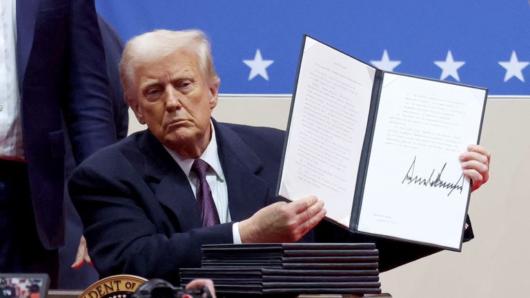Donald Trump shows his signature on an executive order.
Pic: Reuters