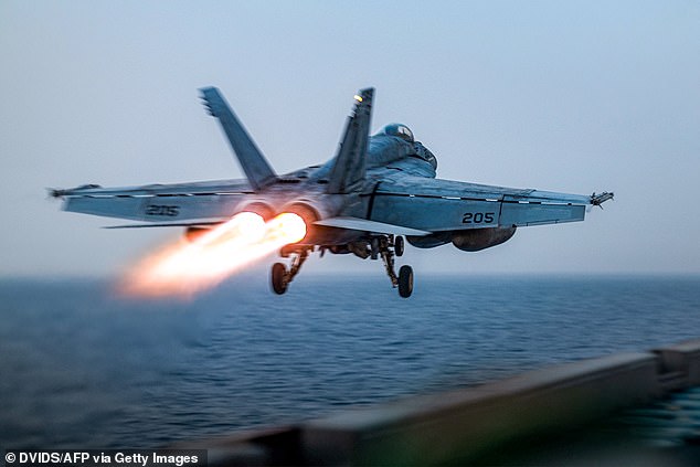 The crew members who were in the pilot seat of the Super Hornet and on the small towing tractor both jumped out before the jet and the tug went into the Red Sea (pictured: US F/A-18 Super Hornet attack fighter jet taking off from the US Navy's USS Harry S. Truman)