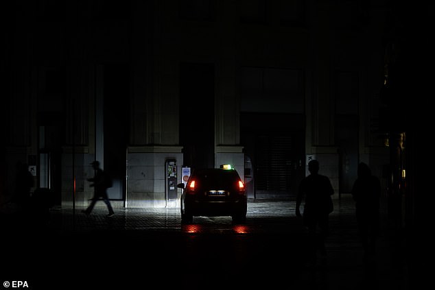Since Spain has lots of renewables and very little power storage, it is more vulnerable to cascading power failures. Pictured: A person walks down a downtown street during a power outage in Malaga on Tuesday