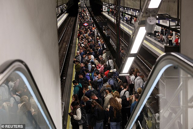 Some have suggested that a cyberattack could be behind the blackout. Pictured: People wait for the metro to arrive at a station in Madrid, as metro operations resume partially