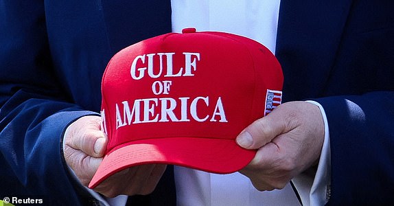 U.S. President Donald Trump holds a cap with the words "Gulf of America" embroidered as he walks to board Marine One to depart for Michigan to attend a rally to celebrate his first 100 days in office, from the South Lawn of the White House in Washington, D.C., U.S., April 29, 2025. REUTERS/Leah Millis