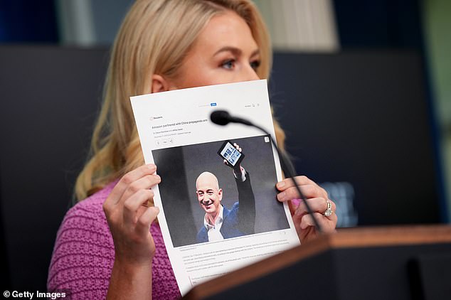 White House press secretary Karoline Leavitt holds a news article on Amazon CEO Jeff Bezos