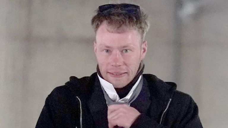 Adam Carruthers adjusts his tie outside court