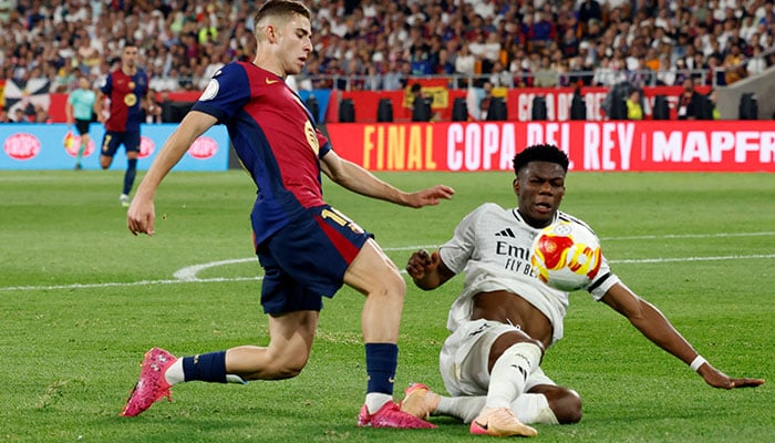 Real Madrids Aurelien Tchouameni in action with FC Barcelonas Fermin Lopez in Copa del Rey final at Estadio de La Cartuja, Seville, Spain on April 27, 2025. — Reuters