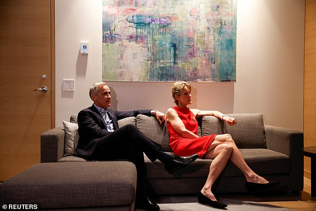 Canada's Prime Minister Mark Carney (pictured left) and his wife Diana Fox Carney (pictured right) watch the coverage of the election results at a hotel in downtown Ottawa