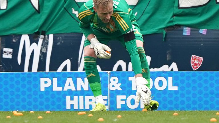 Celtic goalkeeper Viljami Sinisalo picks up fruit missiles thrown on to the pitch during the William Hill Premiership match at Tannadice Park, Dundee. Picture date: Saturday April 26, 2025. PA Photo. See PA story SOCCER Dundee Utd. Photo credit should read: Andrew Milligan/PA Wire...RESTRICTIONS: Use subject to restrictions. Editorial use only, no commercial use without prior consent from rights holder.
