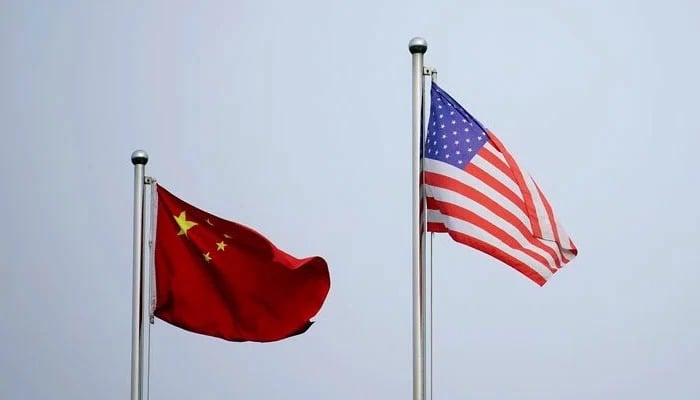 Chinese and US flags flutter outside a company building in Shanghai, China, April 14, 2021. — Reuters