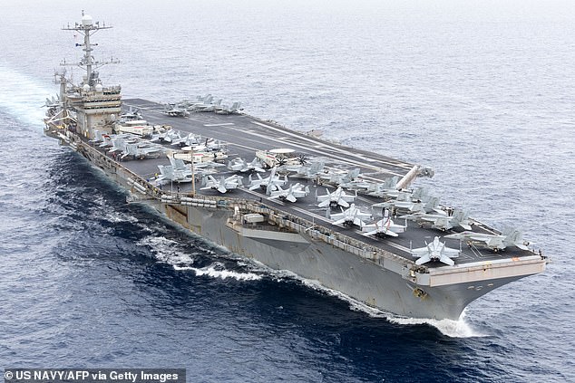 An F/A-18 fighter jet slipped off the hanger deck of an aircraft carrier deployed to the Middle East, as sailors were towing the aircraft into place in the hangar bay of the USS Harry S. Truman on Monday, the Navy said