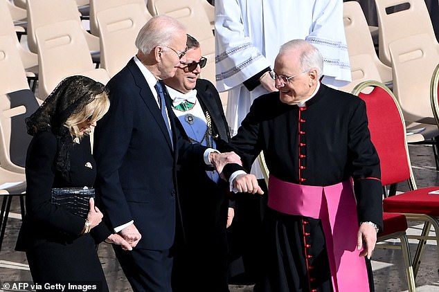 Biden, 82, clasped onto the priest's forearm as he made a rare public appearance at the Vatican's Saint Peter's Square