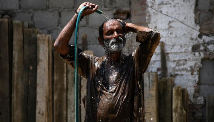 A man cools off with a water hose during a hot summer day in Hyderabad, May 24, 2024. — Reuters