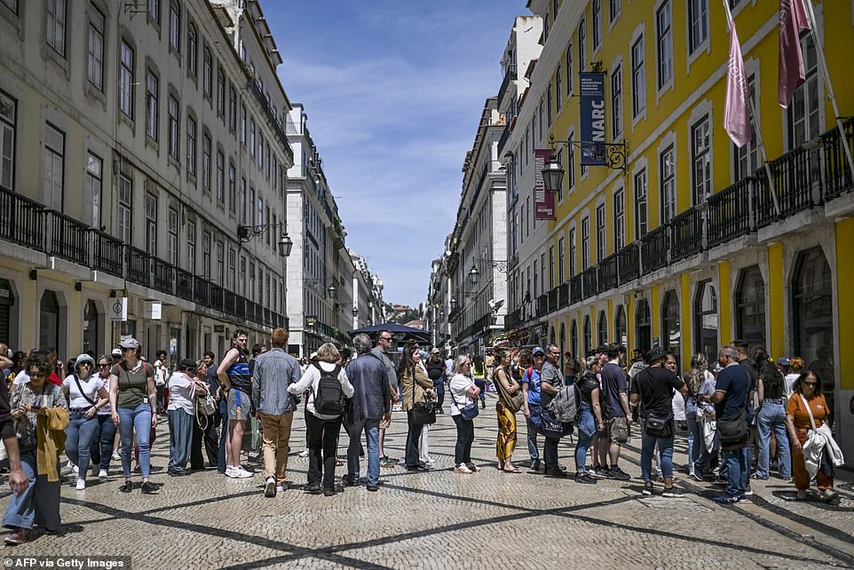 People queue for the ATM at downtown Lisbon on April 28 during a massive power cut affecting the entire Iberian peninsula
