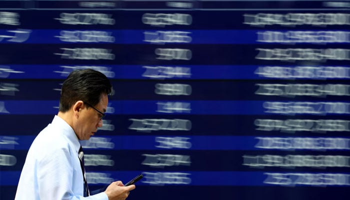 A man walks past an electronic screen displaying stock quotation board in Tokyo, Japan April 15, 2025. —Reuters