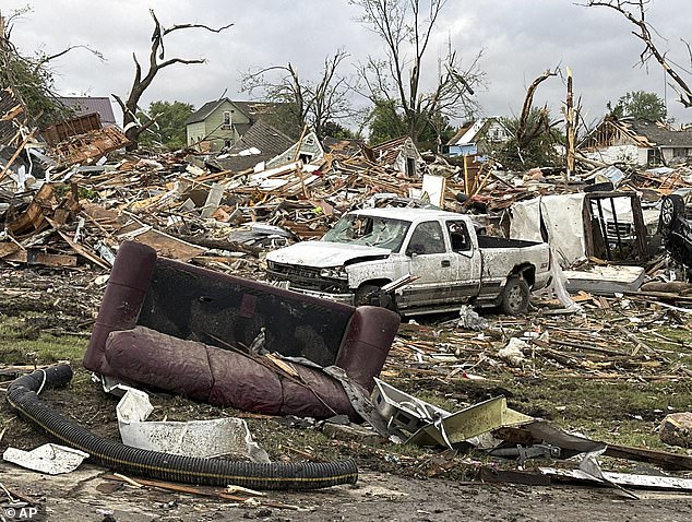 Damage as a result of global warming can come in the form of wildfires, crop damage and extreme weather events like floods and storms. Pictured, damage after a tornado moved through Greenfield, Iowa, Tuesday, May 21, 2024