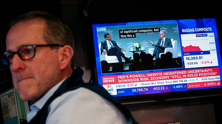A trader works on the floor at the New York Stock Exchange, as a screen broadcasts a live interview with US Federal Reserve Chair Jay Powell on 16 April 2025. File pic: Reuters