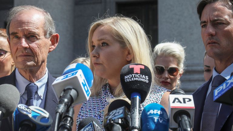 FILE - Virginia Giuffre, center, holds a news conference outside a Manhattan court in New York, Aug. 27, 2019. (AP Photo/Bebeto Matthews, File)