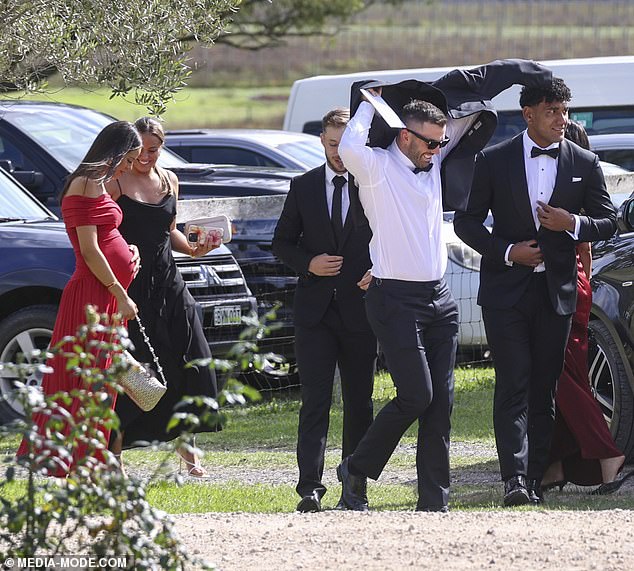Maria (first left) showed off her baby bump as she dazzled in a red dress as she arrived with her husband and his team-mates