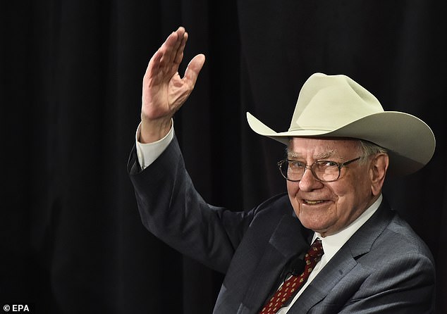 Buffett waves to the crowd after playing a ukulele while wearing a cowboy hat after answering questions for a crowd inside his new North Texas store for a cancer benefit
