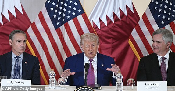 US President Donald Trump (C) is flanked with Boeing CEO Kelly Ortberg (L) and CEO of GE Aerospace Larry Culp during a breakfast with business leaders in Doha on May 15, 2025. (Photo by Brendan SMIALOWSKI / AFP) (Photo by BRENDAN SMIALOWSKI/AFP via Getty Images)
